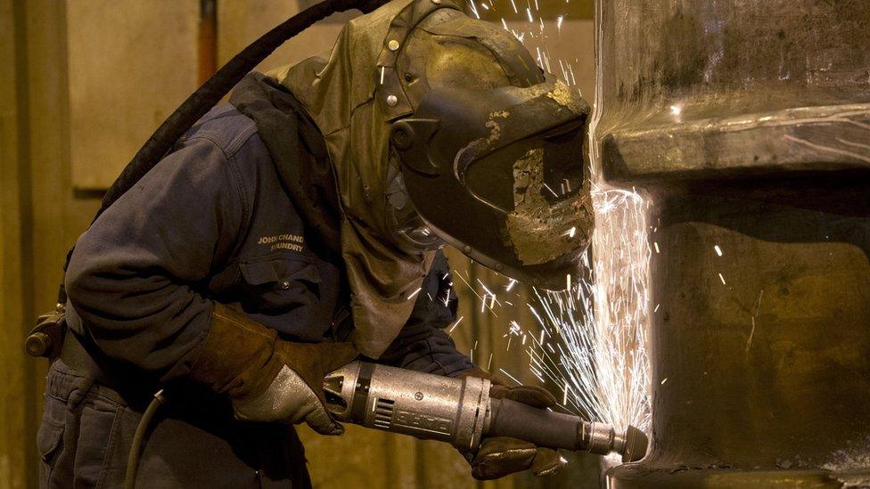 A grinder works on a freshly cast piece of steel in a foundry in Sheffield