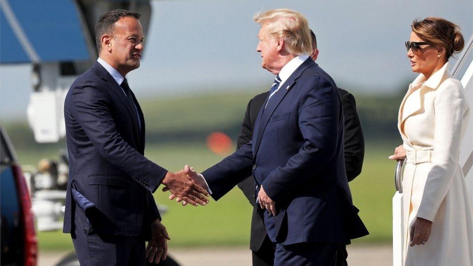 US President Donald Trump (C) being greeted by Irish Prime Minsiter Leo Varadkar (L) upon disembarking Air Force One upon arrival at Shannon Airport in Shannon, County Clare, Ireland