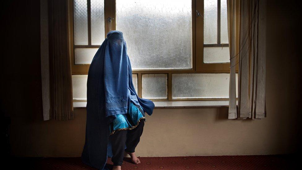 Woman covered with a burqa in a home