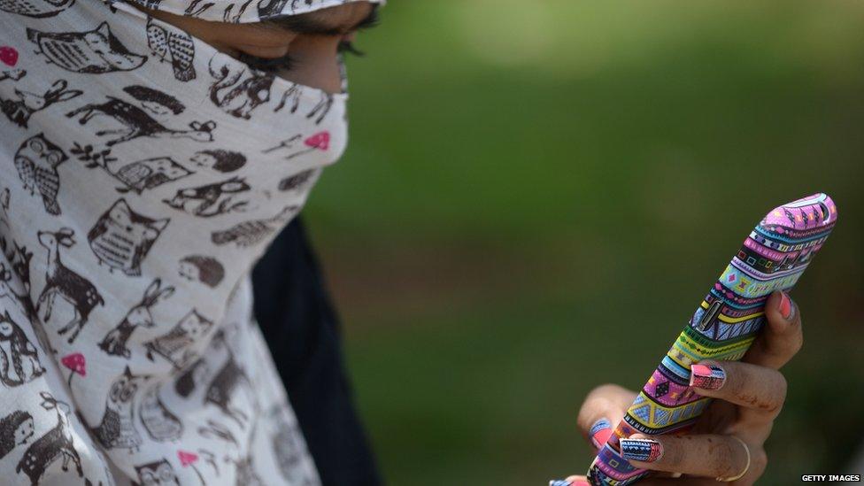 An Indian woman looks at her mobile phone