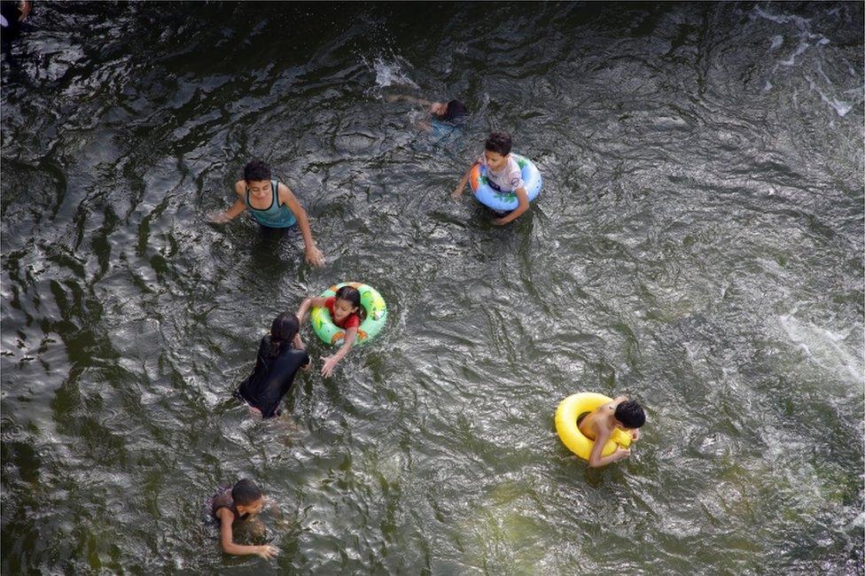 Children swim in the water of the Nile.