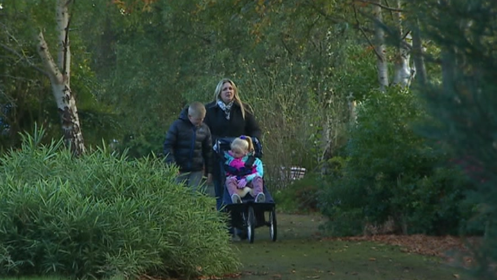 Photo of Mrs Groves and her two children in their garden