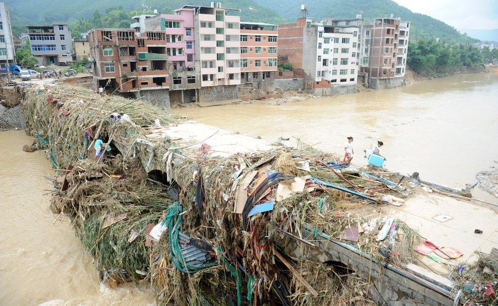 A bridge, high above water level now, covered in debris left by the floodwaters. Fuzhou, Fujian Province, China, 11 July 2016.