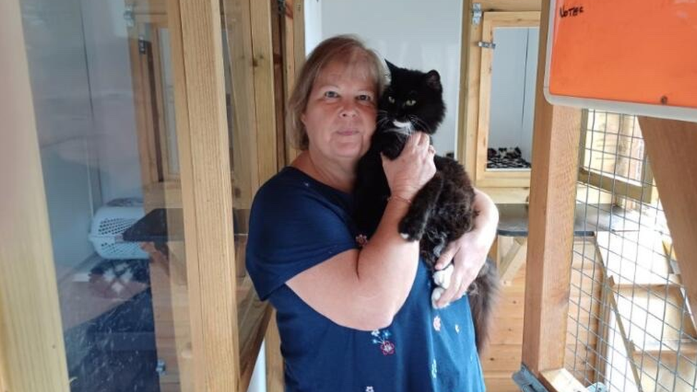 woman holding black cat