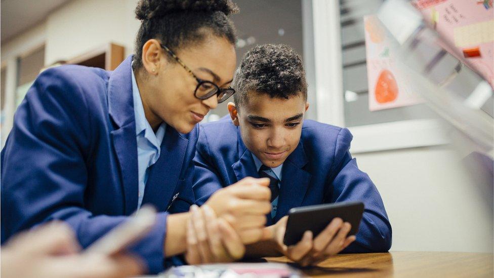 two students looking at a mobile phone