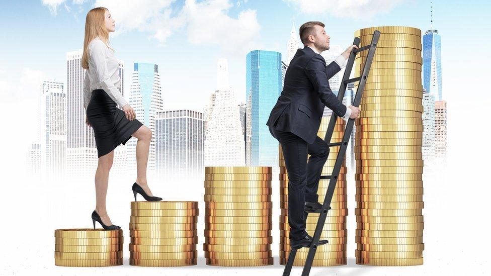 man and woman climbing piles of coins