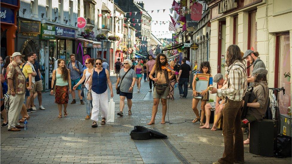 Stock image of musicians playing Irish folk music on the sunny streets of Galway