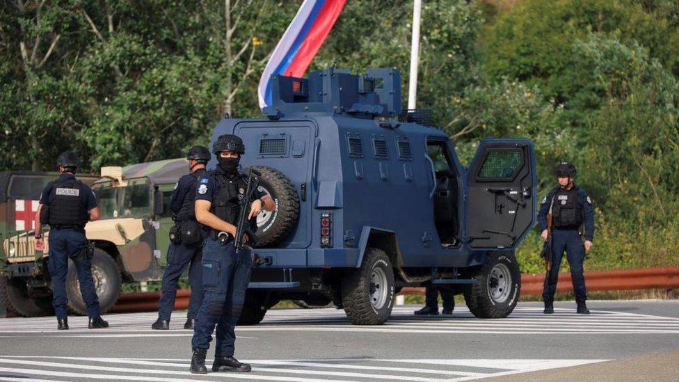 police work with US and EU troops in the background