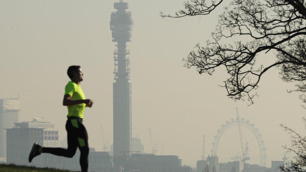 A man running against a backdrop of a London skyline showing polluted air