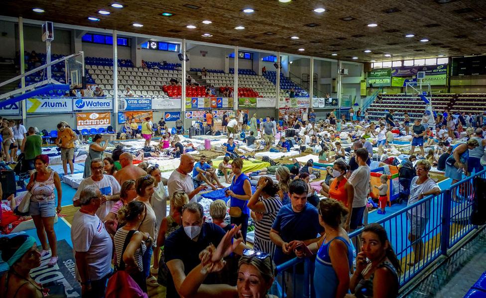 Tourists are sheltered in a stadium after being evacuated following a wildfire on the island of Rhodes