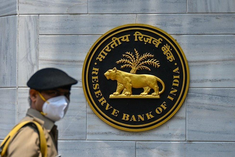 A security personal walks past an entrance of the Reserve Bank of India (RBI) headquarters in Mumbai on May 5, 2021.