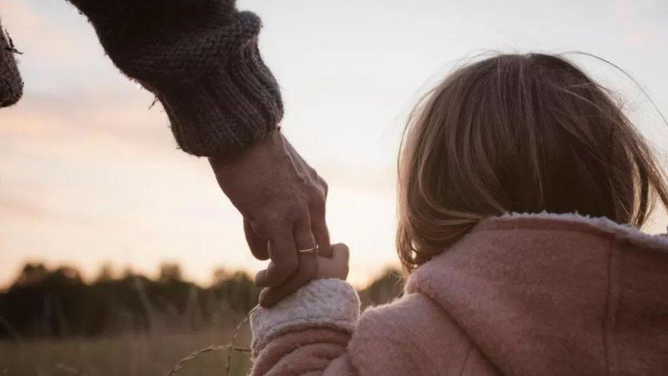 Older person holding a child's hand