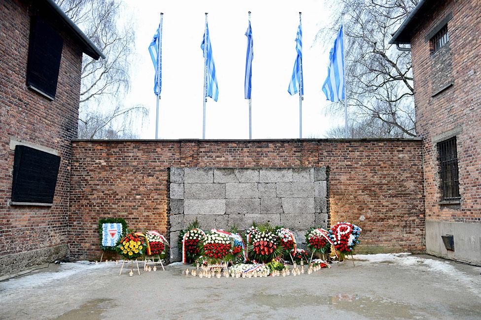 Candles and wreaths at the "death wall", where Nazi SS soldiers shot and killed several thousand victims in Auschwitz-Birkenau concentration camp