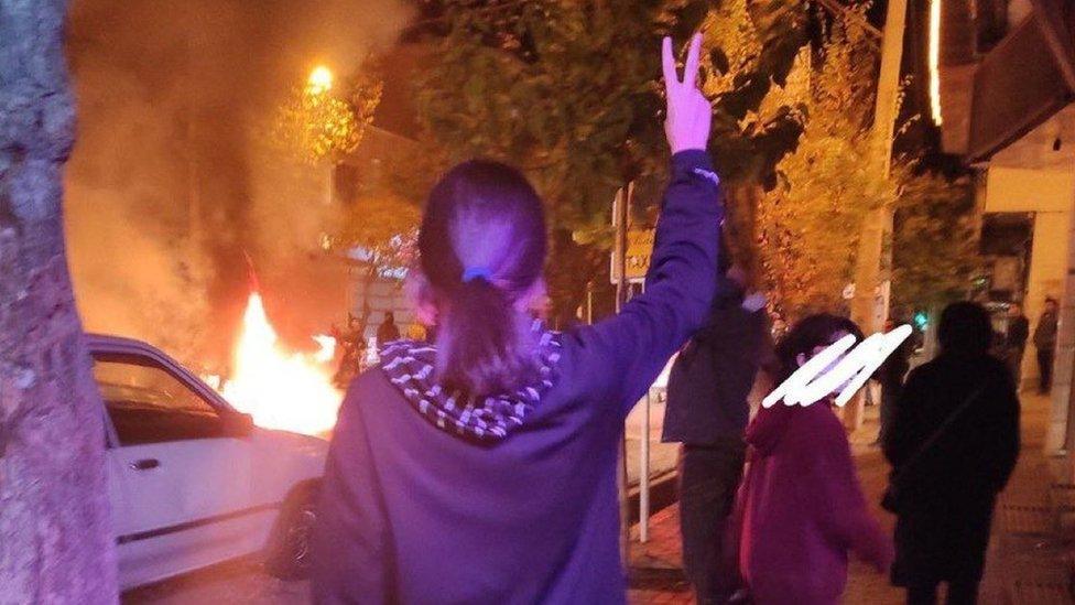 A woman without a headscarf gestures at a protest in Zarrin Shahr, Isfahan, Iran (15 November 2022)