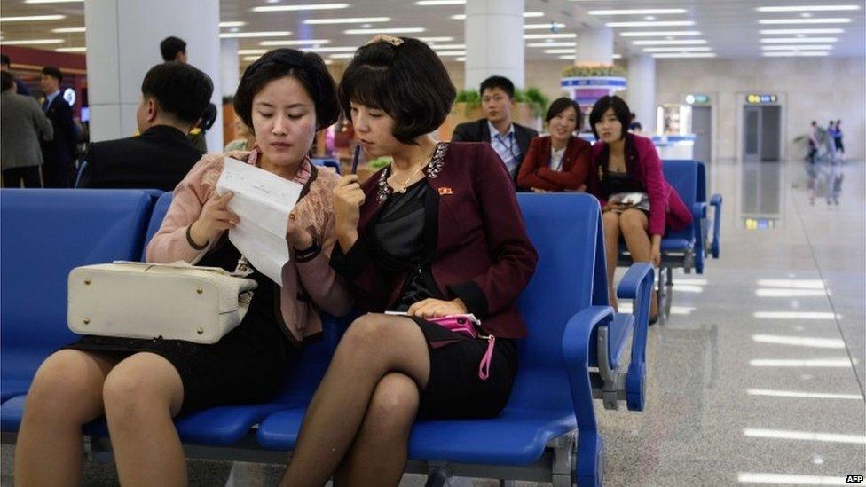 Women sitting at Pyongyang's international airport, 8 October 2015