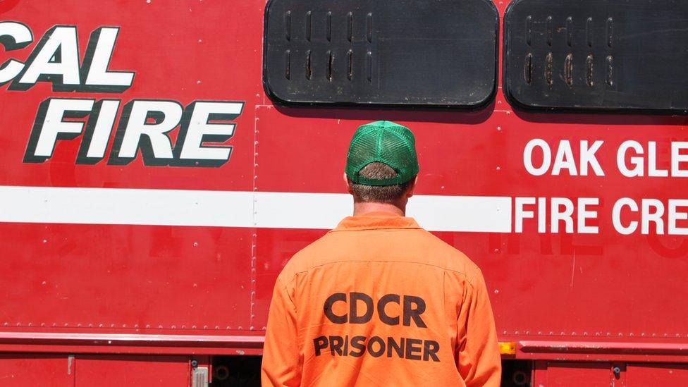 Prisoner standing in front of Cal Fire engine