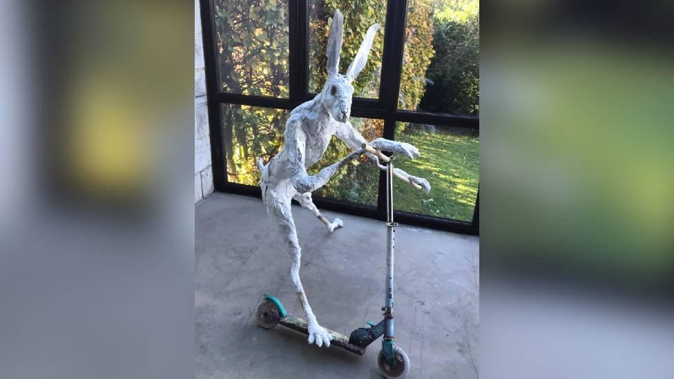 Sculpture of a hare on a child's scooter