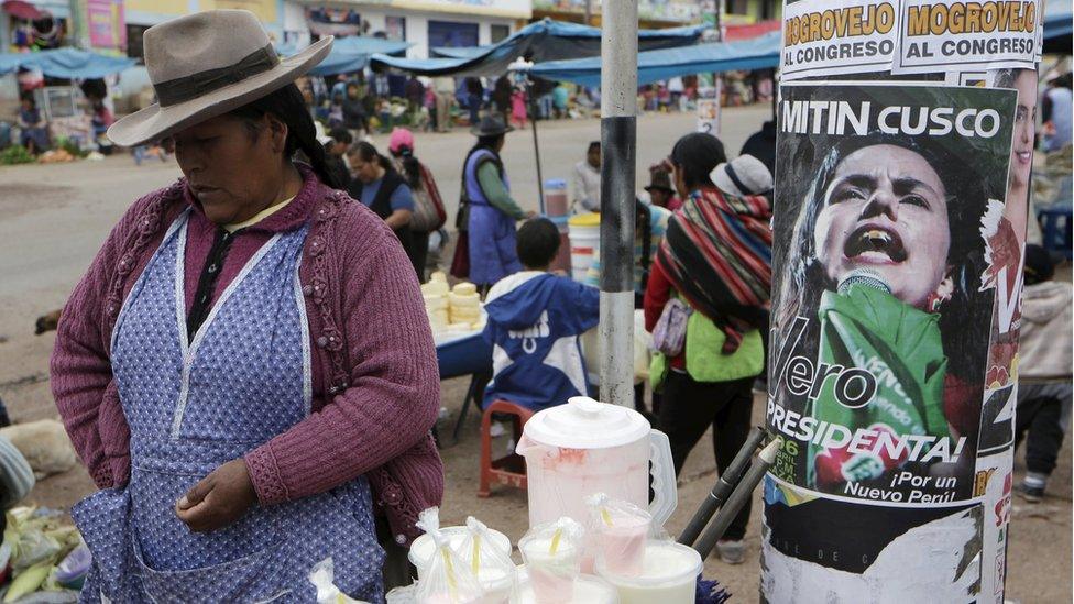 A woman sells yogurt next to a sign of Peru"s presidential candidate Veronika Mendoza in Cuzco, April 9, 2016