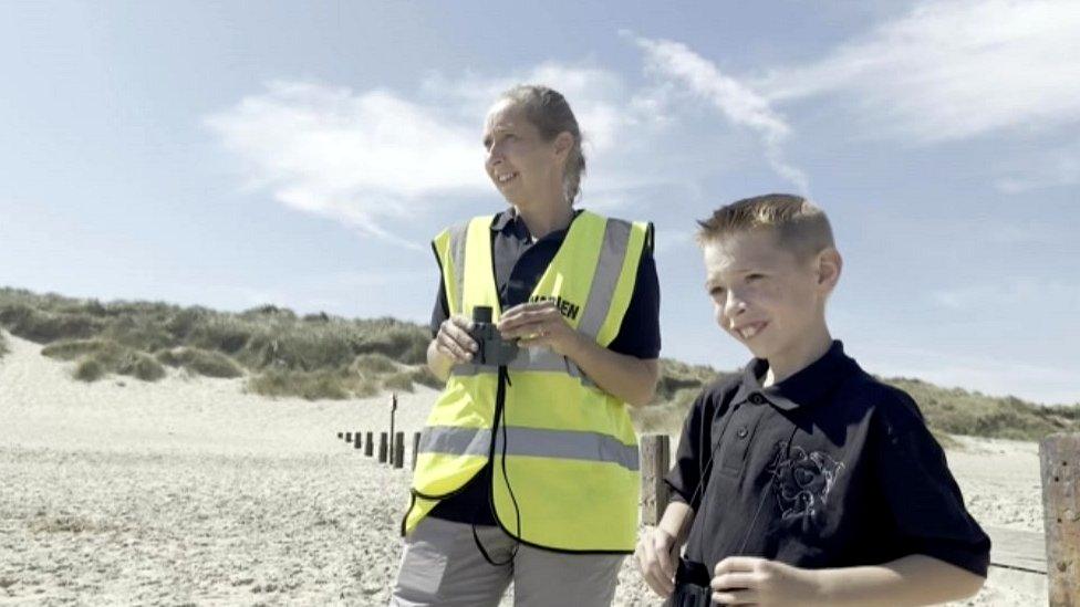 Theo and his mum Hannah on the beach with their binoculars