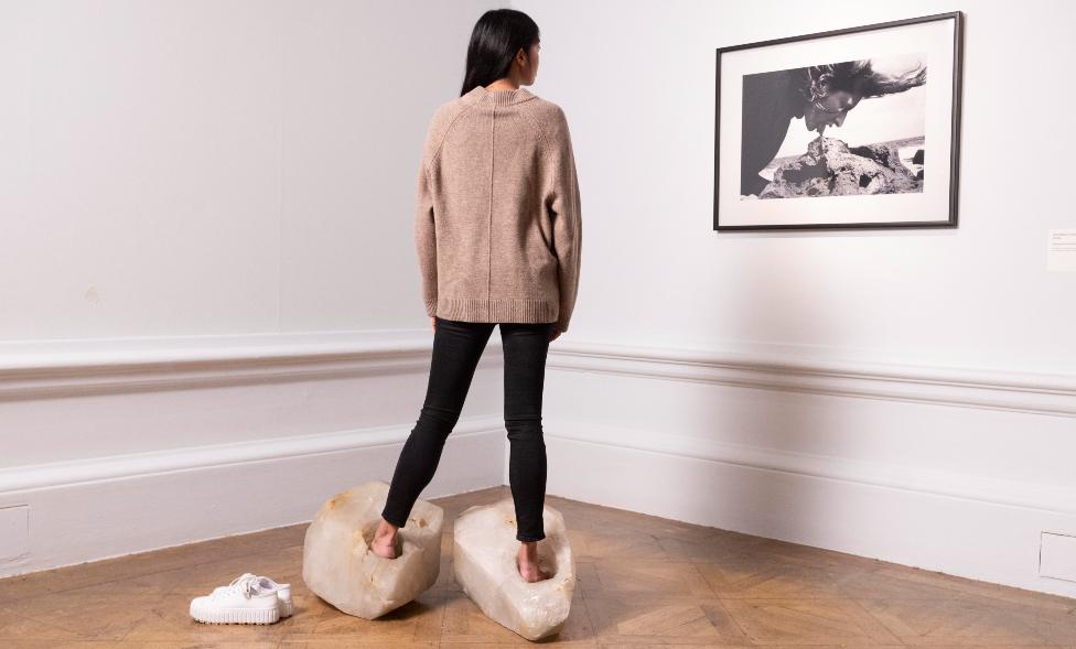 A woman looks at art work by Marina Abramović