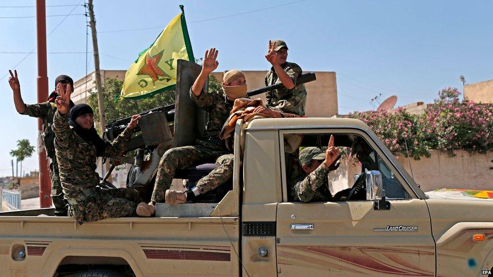 Members of Kurdish Popular Protection Units (YPG) flash victory sign in Raqqa province, Syria (23 June 2015)