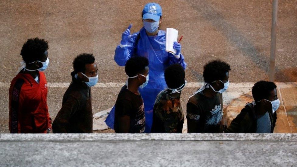 Rescued migrants are being checked by a United Nations High Commissioner for Refugees (UNHCR) worker