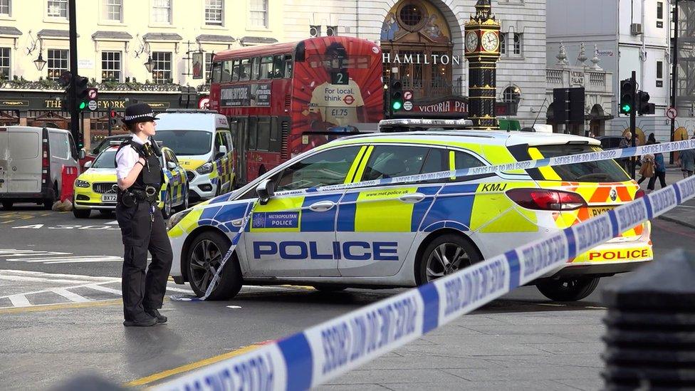 Police car and blue police tape at the scene