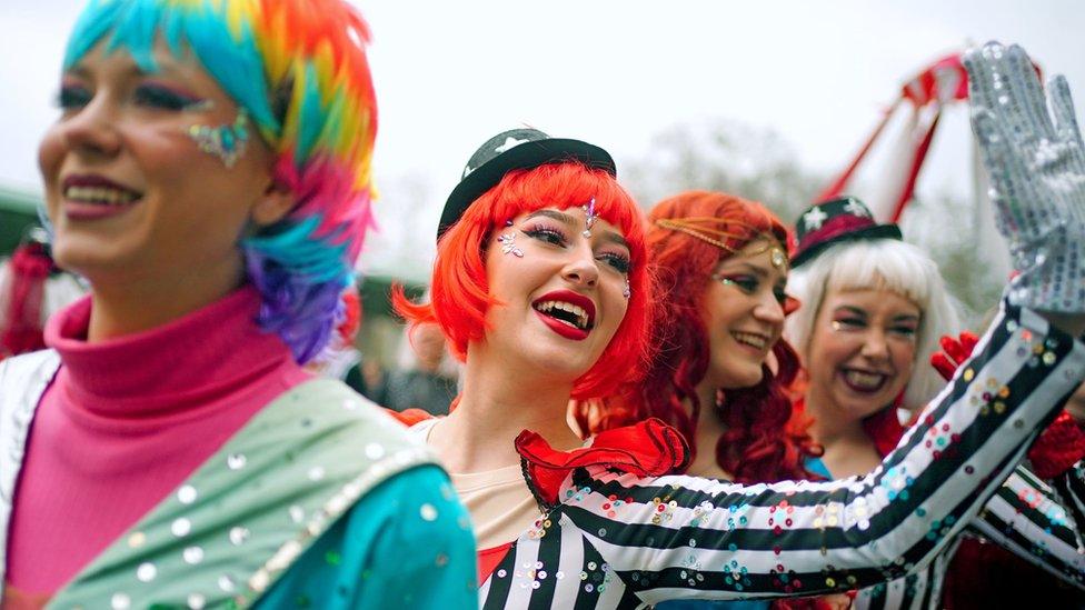 Performers in colourful costumes and wigs