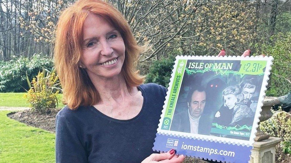 Jane Asher holding the stamp featuring her