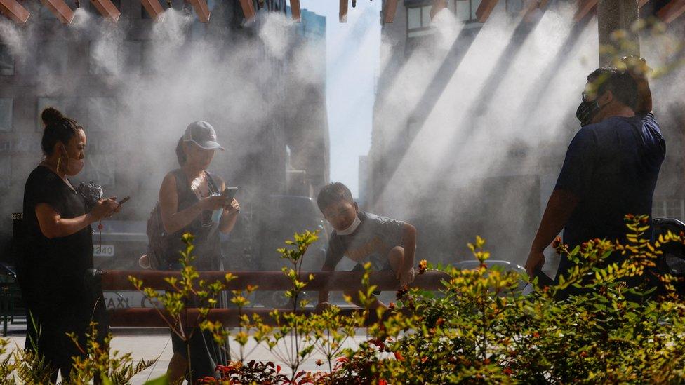 People take a break under a cooling mist in Tokyo