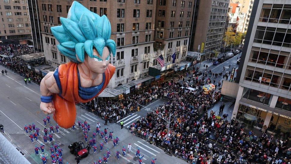 An aerial view of Macy's Thanksgiving Day Parade - including a large balloon character