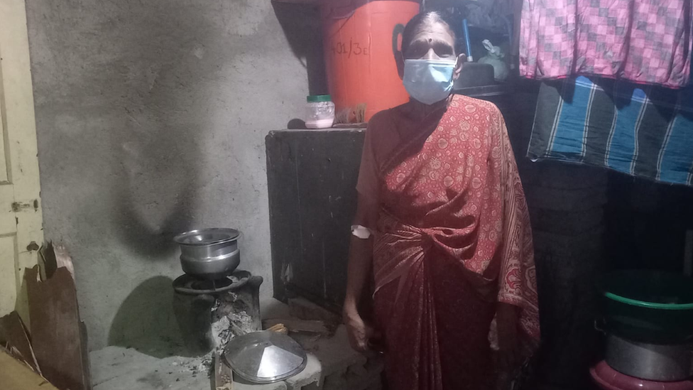 A Sri Lankan woman cooks on open flame in her home