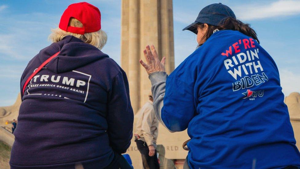 Two women sitting - one a Trump supporter the other Biden supporter