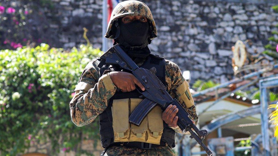 A Haitian police officer stands guard outside of the presidential residence on 7 July, 2021 in Port-au-Prince, Haiti.