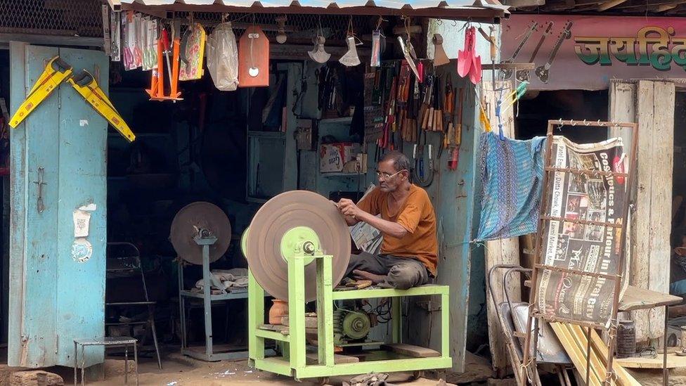 A shop in Miraj with instruments on display while an artisan works