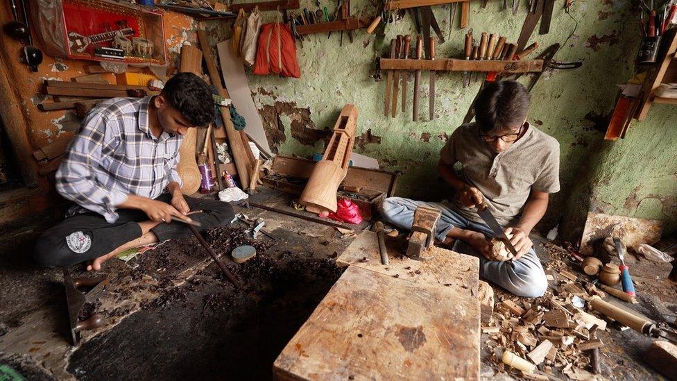 Artists work on their instruments in their workshop