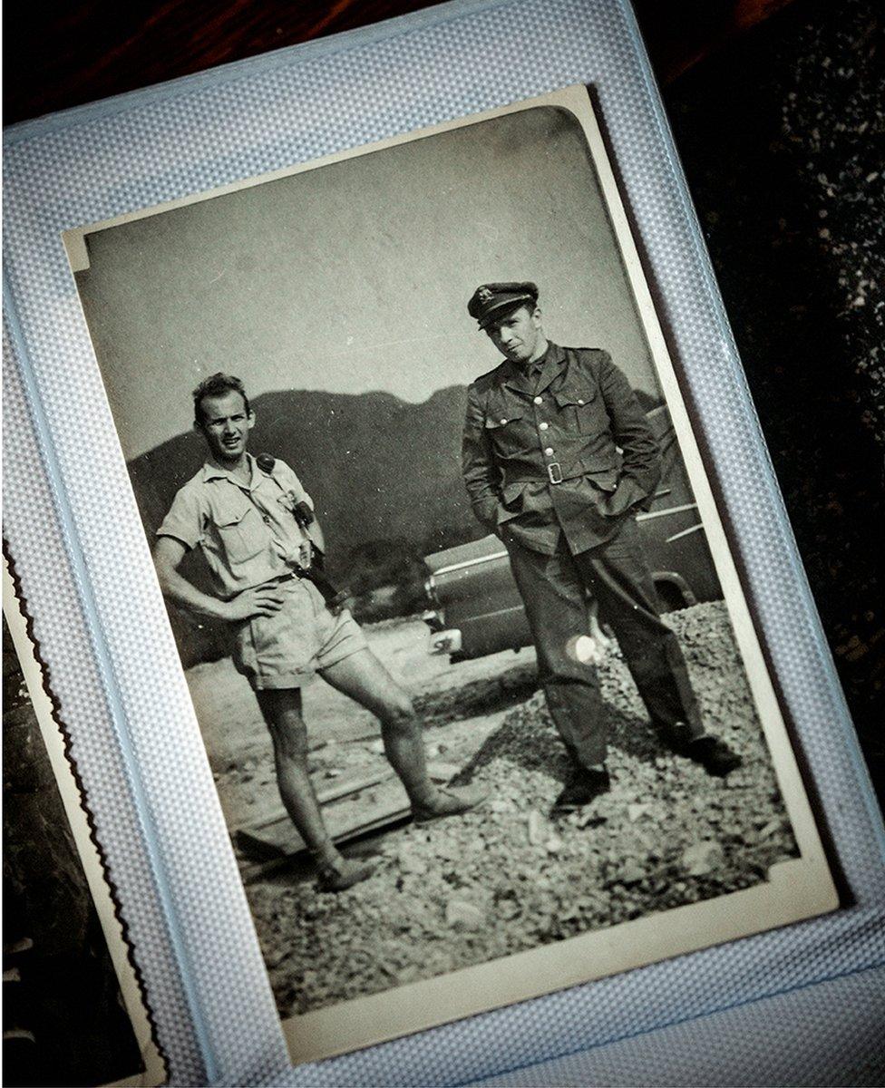 Black and white photo pf two men standing - one in uniform