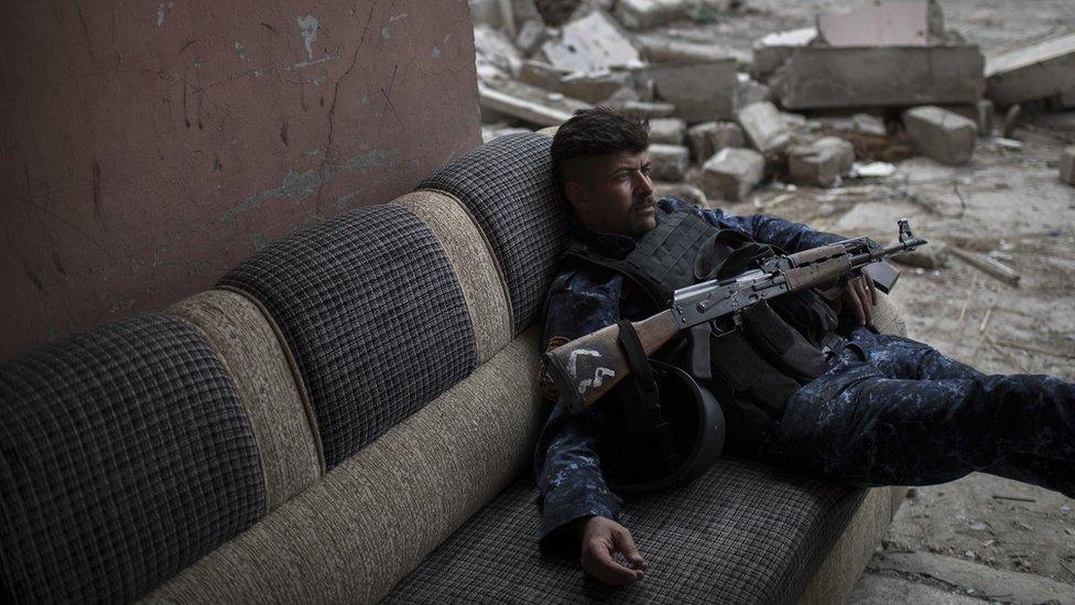 A Federal Police soldier lays on a couch before moving to a front line near the old city during fighting against Islamic State militants on the western side of in Mosul, Iraq, Tuesday, March 28, 2017. (