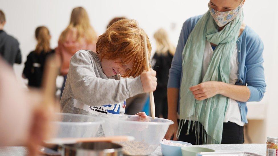 Boy mixes mixture in mixing bowl