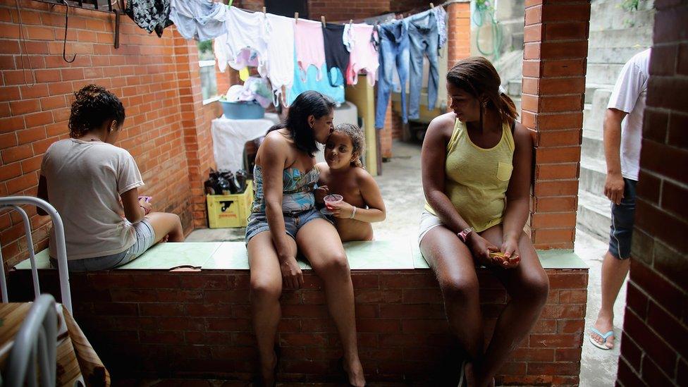 Members of the Das Neves family sit in their home in the Prazeres favela in Rio de Janeiro. The family participates in Brazil's 'Bolsa Familia' programme