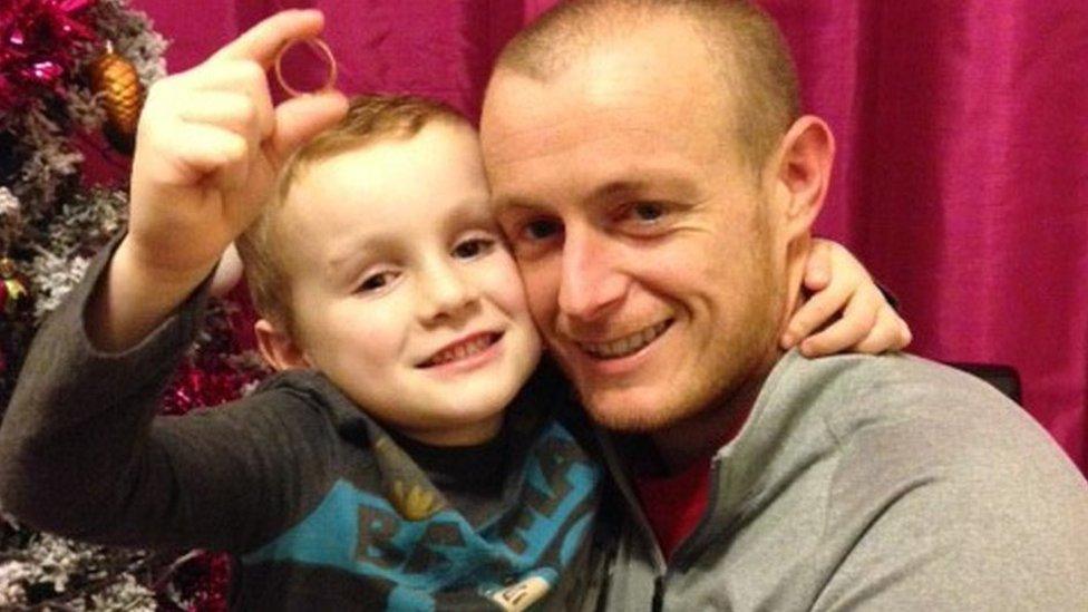 Osian with his dad Simon and his wedding ring he found in the Christmas decorations