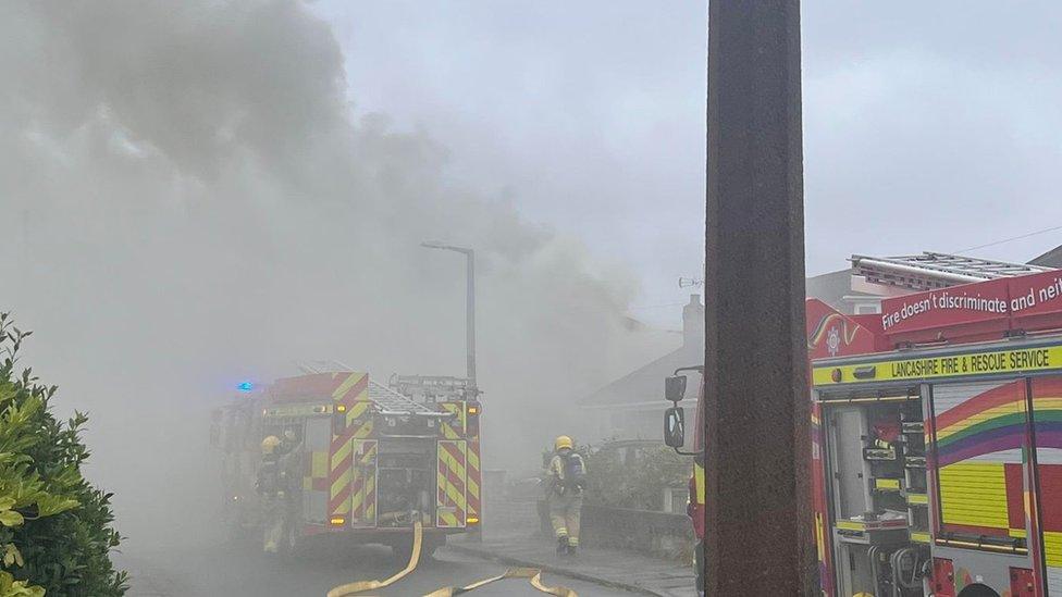 Smoke plume and fire engines at house blaze