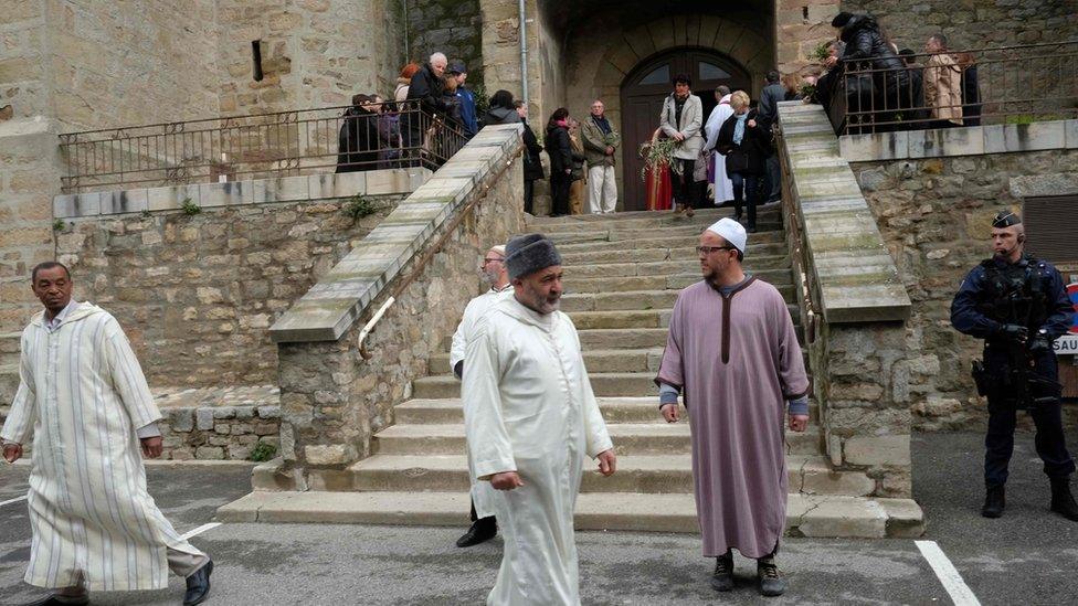 Muslim mourners leave the church service