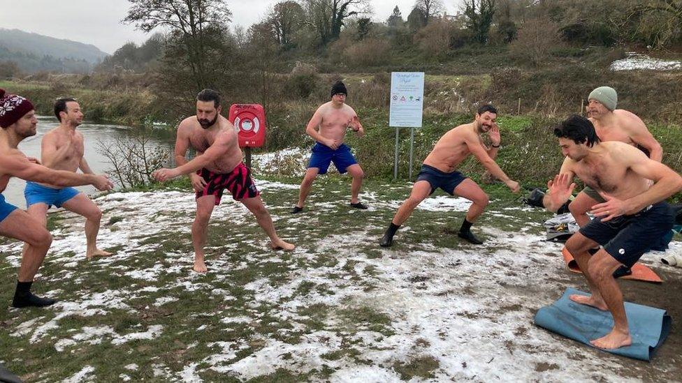 Group doing breathing exercises on snowy grass