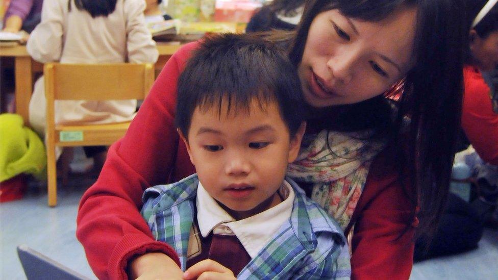 A boy and his mother read a book in the Taipei public library in Taipei on November 18, 2012.