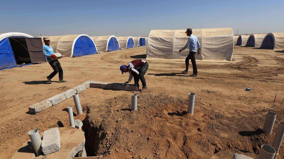 Workers prepare emergency shelters for people displaced by the Mosul offensive in Hasan Sham (6 October 2016)