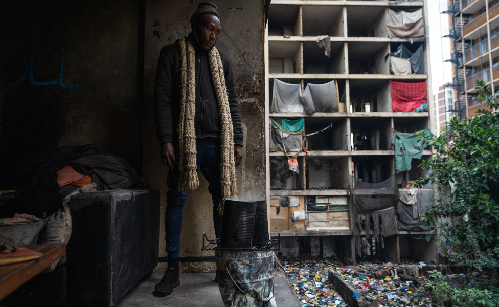 Sabelo Mapempeni stands in one of the rooms looking out of the derelict San Jose building in Johannesburg, South Africa