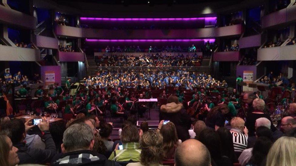 Hundreds of children performing on stage in front of a full audience at the Derngate Theatre