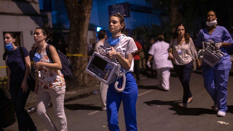 Employees are seen after a fire hit the Badim Hospital in Rio de Janeiro, Brazil September 12, 2019