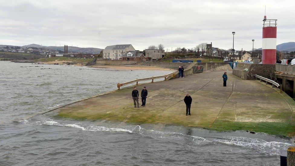 people stand on Buncrana pier, where the family's car entered the water